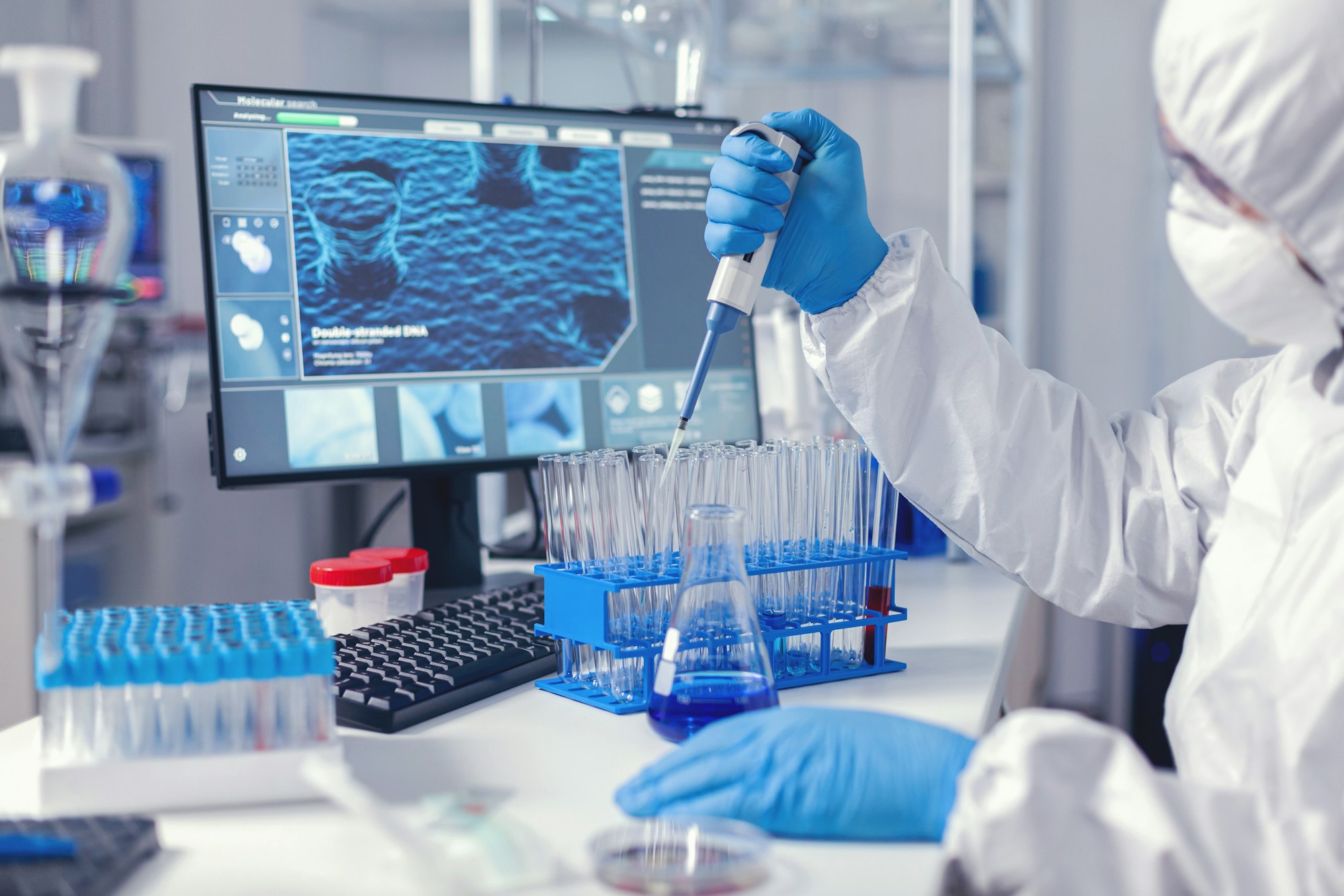 Laborant dropping sample in test tube using micropipette